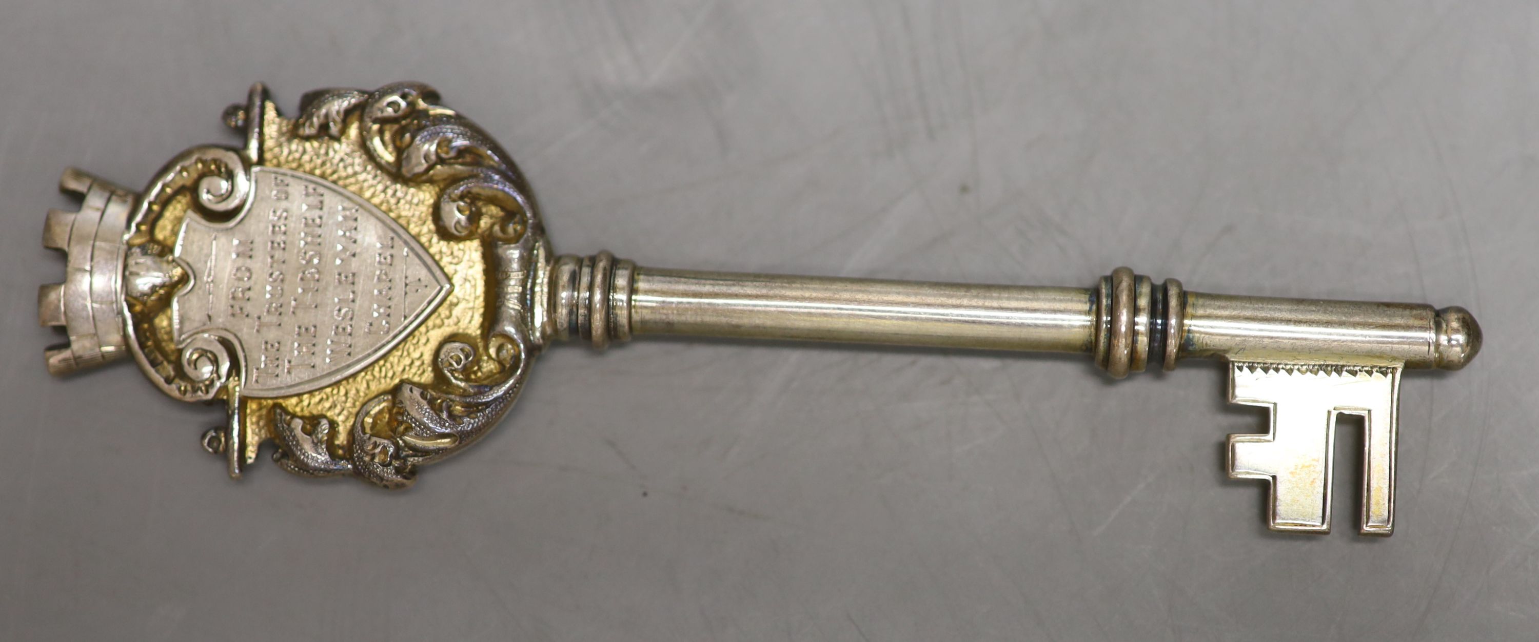 A cased Edwardian parcel gilt silver presentation key, Birmingham, 1908, 10.2cm and a late Victorian silver medallion.